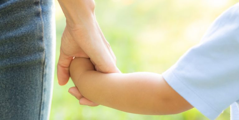 parent holding childs hand at blue windmill day nursery