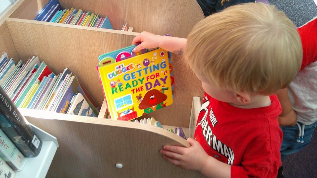 baby choosing a book at Rugby mobile library from blue windmill nursery