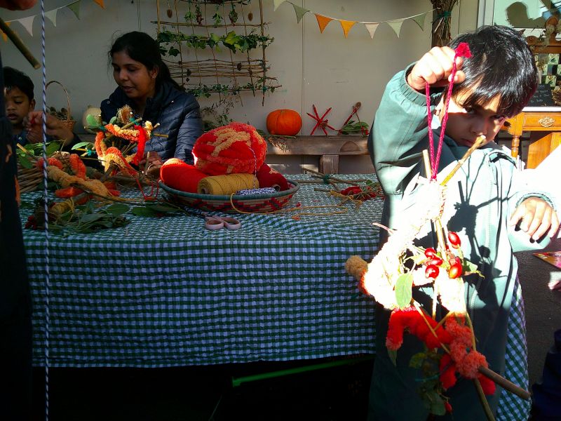 a little boy showing off his autumn weaving activities at nursery with families in rugby