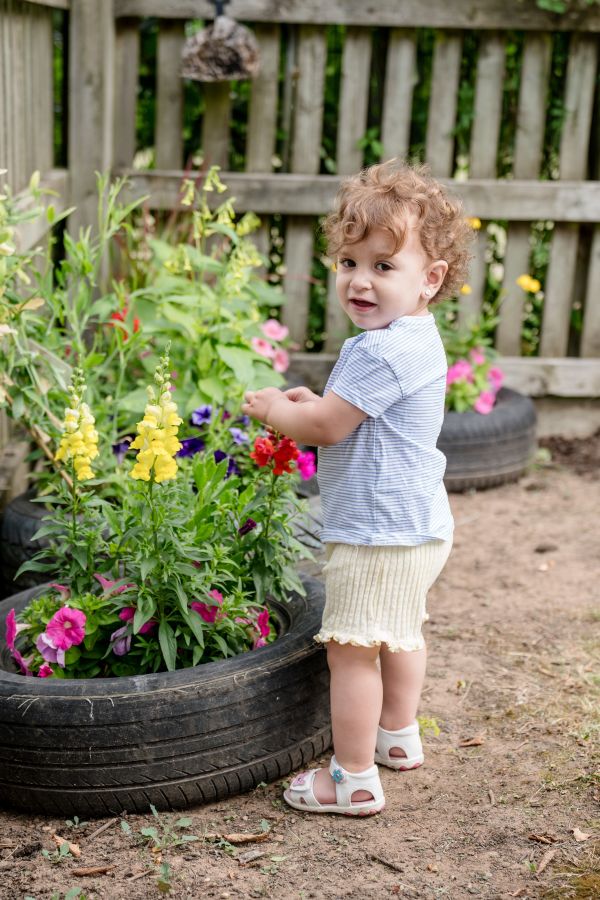 a little girl picking flowers in the garden at blue windmill nursery in rugby